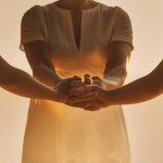 Family circle holding hands in prayer for family and friends during evening devotion time