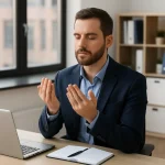 Person practicing afternoon prayer in peaceful office setting with natural light